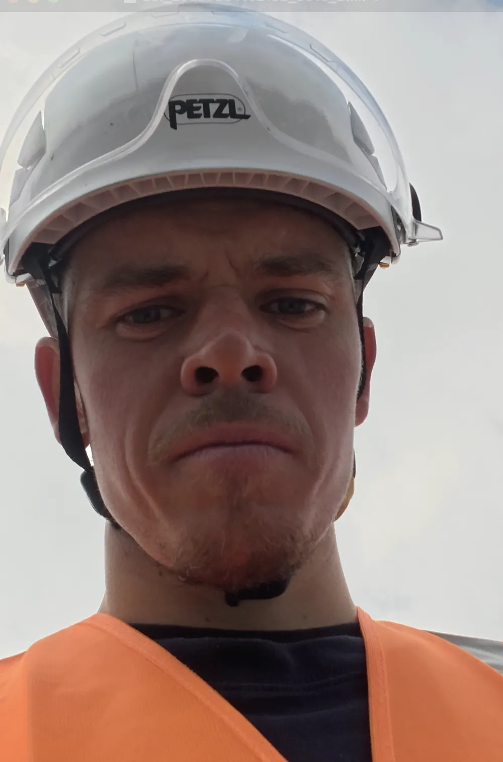 Collaborateur en casque de chantier et gilet haute visibilité sur site industriel